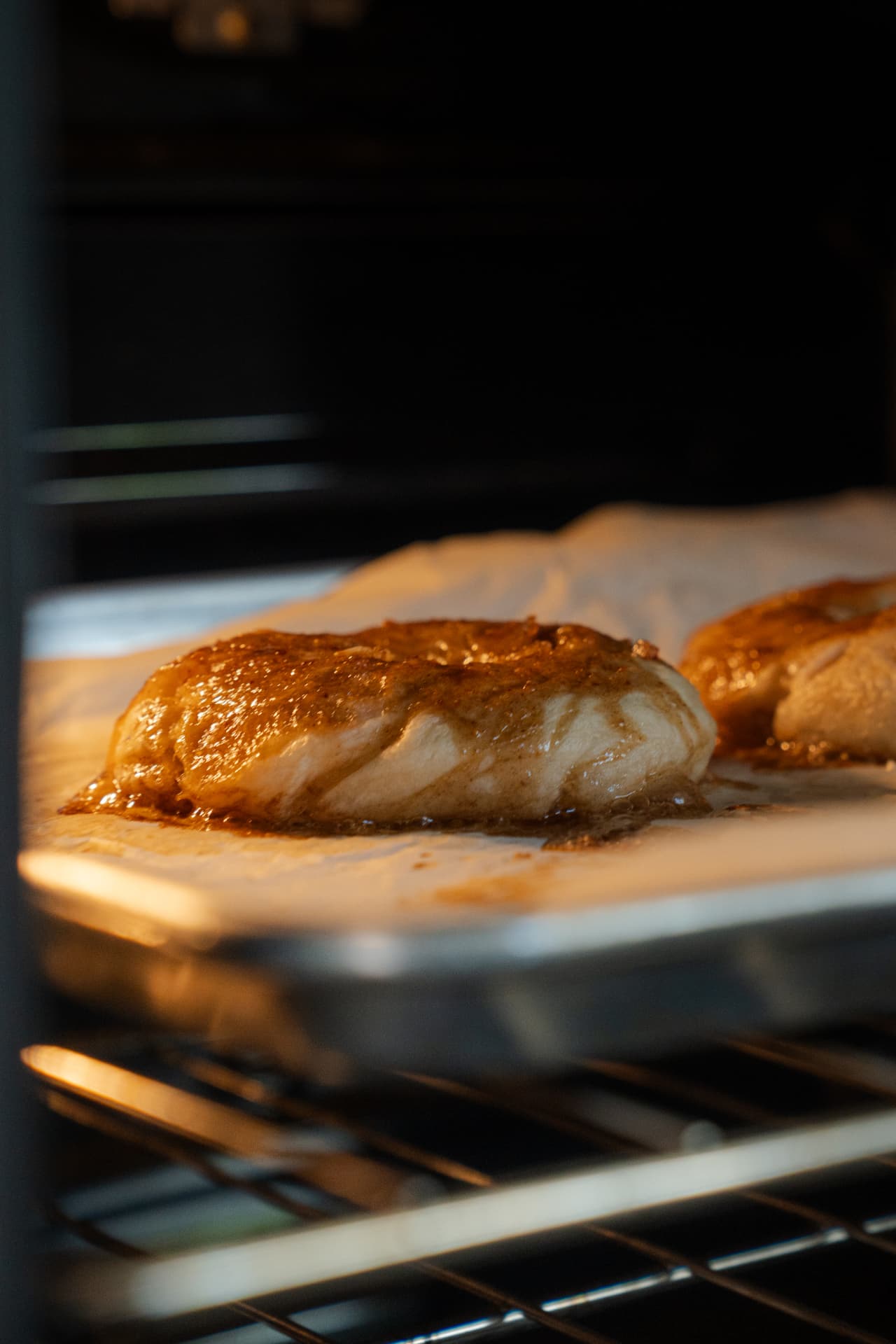 A golden brown bagel baking on parchment paper